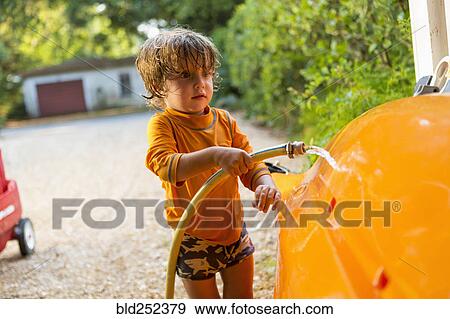 Caucasian boy washing kayak with hose View Large Photo Image Stock Photo - Caucasian boy washing kayak with hose. Fotosearch