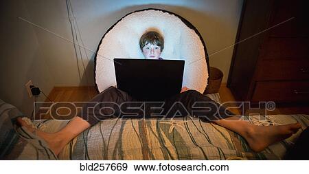 Caucasian boy with feet up using laptop View Large Photo Image Stock Photo - Caucasian boy with feet up using laptop. Fotosearch