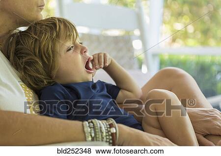 Caucasian boy yawning in the lap of mother View Large Photo Image Stock Photo - Caucasian boy yawning in the lap of mother. Fotosearch