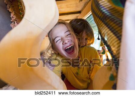 Caucasian brother and sister laughing under table View Large Photo Image Stock Image - Caucasian brother and sister laughing under table. Fotosearch