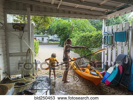 Caucasian brother and sister rinsing kayak with hose View Large Photo Image Stock Image - Caucasian brother and sister rinsing kayak with hose. Fotosearch