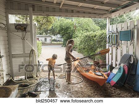Caucasian brother and sister rinsing kayak with hose View Large Photo Image Stock Photo - Caucasian brother and sister rinsing kayak with hose. Fotosearch