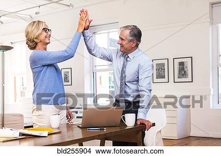 Picture - Caucasian business people high-fiving. Fotosearch