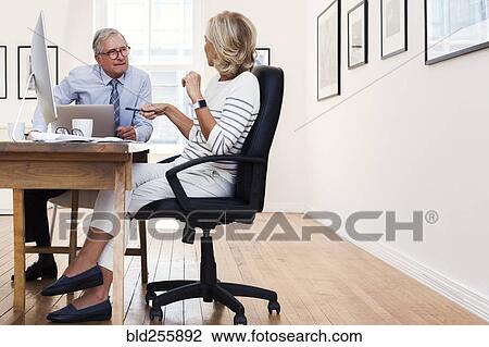 Caucasian businessman and businesswoman talking at table View Large Photo Image Stock Image - Caucasian businessman and businesswoman talking at table. Fotosearch