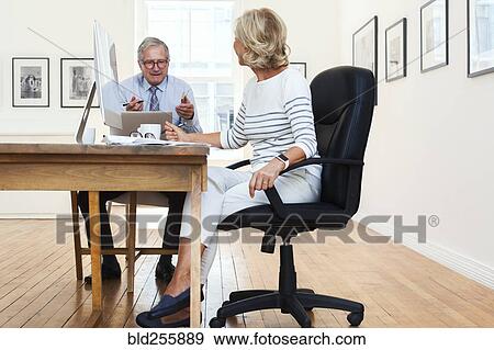 Caucasian businessman and businesswoman talking at table View Large Photo Image Stock Photo - Caucasian businessman and businesswoman talking at table. Fotosearch