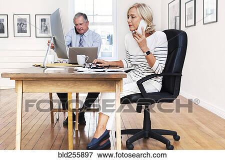 Caucasian businessman and businesswoman talking on cell phones View Large Photo Image Stock Photo - Caucasian businessman and businesswoman talking on cell phones. Fotosearch