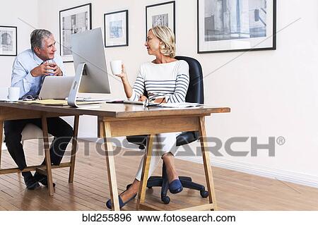 Caucasian businessman and businesswoman talking at table View Large Photo Image Stock Photograph - Caucasian businessman and businesswoman talking at table. Fotosearch
