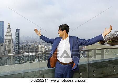 Picture - Caucasian businessman celebrating on urban rooftop. Fotosearch