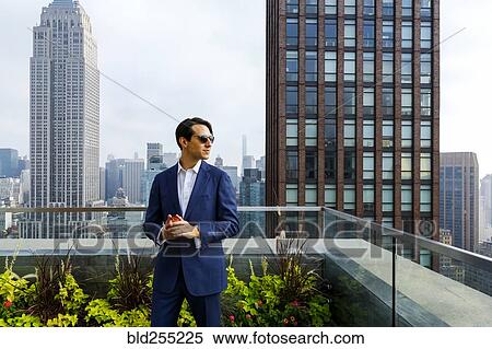 Caucasian businessman holding apple on urban rooftop View Large Photo Image Stock Photography - Caucasian businessman holding apple on urban rooftop. Fotosearch