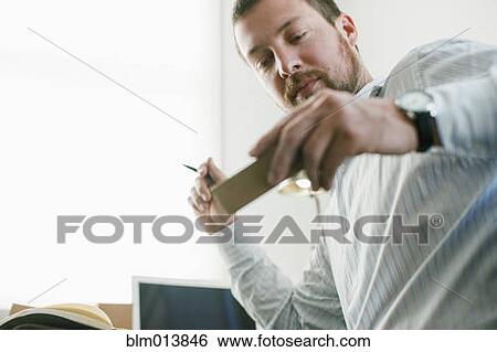 Stock Photograph - Caucasian businessman looking at prototype. Fotosearch