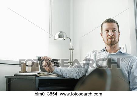 Caucasian businessman sitting at desk with feet up View Large Photo Image Picture - Caucasian businessman sitting at desk with feet up. Fotosearch