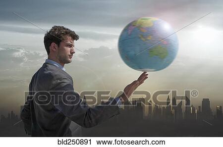 Caucasian businessman spinning globe on finger near city skyline View Large Photo Image Stock Image - Caucasian businessman spinning globe on finger near city skyline. Fotosearch