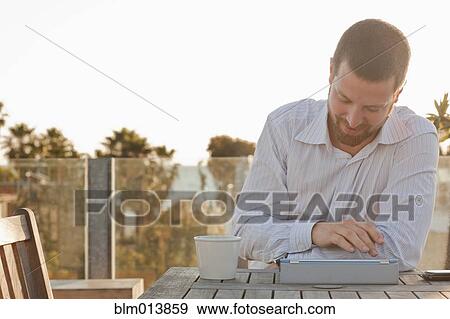 Stock Photo - Caucasian businessman using digital tablet outdoors. Fotosearch