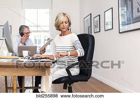 Stock Photo - Caucasian businesswoman checking the time. Fotosearch