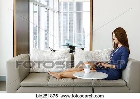 Caucasian businesswoman relaxing on sofa using laptop View Large Photo Image Stock Photography - Caucasian businesswoman relaxing on sofa using laptop. Fotosearch