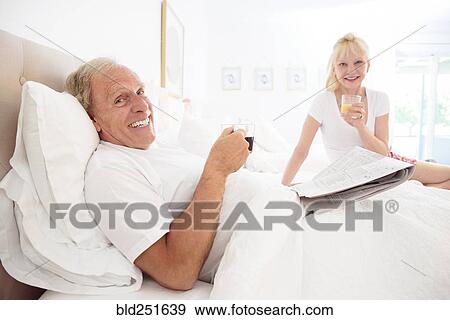Caucasian couple drinking coffee and juice in bed View Large Photo Image Stock Photo - Caucasian couple drinking coffee and juice in bed. Fotosearch