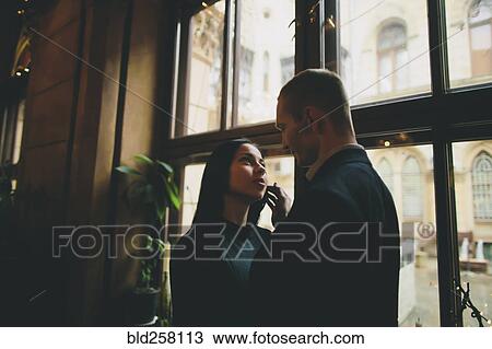 Caucasian couple embracing near window View Large Photo Image Stock Image - Caucasian couple embracing near window. Fotosearch