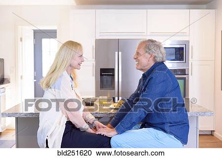 Caucasian couple holding hands in kitchen View Large Photo Image Stock Image - Caucasian couple holding hands in kitchen. Fotosearch