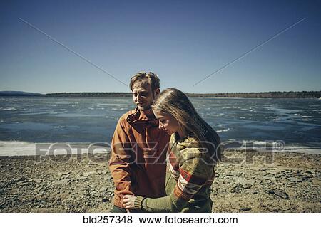 Stock Photo - Caucasian couple holding hands on beach. Fotosearch