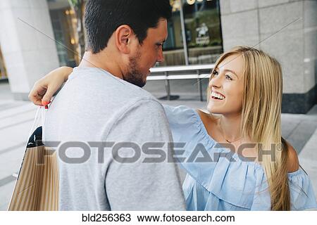 Caucasian couple hugging and carrying shopping bags View Large Photo Image Stock Image - Caucasian couple hugging and carrying shopping bags. Fotosearch