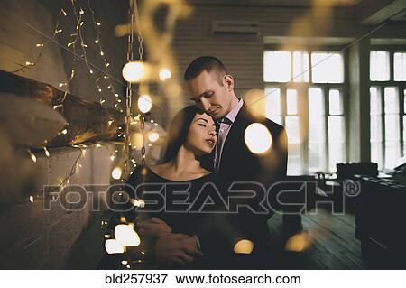 Caucasian couple hugging near wall View Large Photo Image Stock Photo - Caucasian couple hugging near wall. Fotosearch