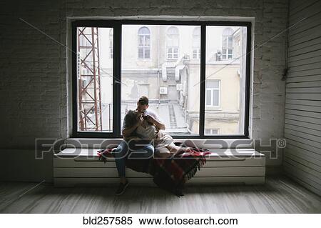 Caucasian couple kissing on bench near window View Large Photo Image Stock Photography - Caucasian couple kissing on bench near window. Fotosearch