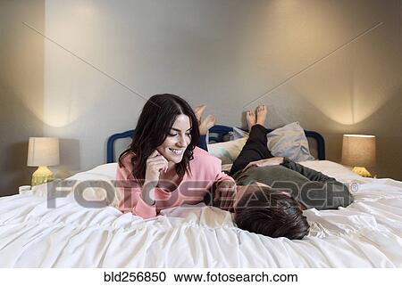 Caucasian couple laying on bed View Large Photo Image Stock Image - Caucasian couple laying on bed. Fotosearch