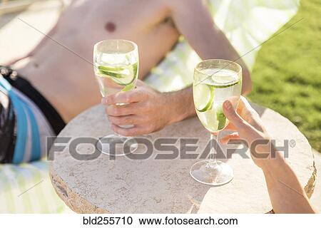 Caucasian couple relaxing in lounge chairs holding drinks View Large Photo Image Stock Image - Caucasian couple relaxing in lounge chairs holding drinks. Fotosearch