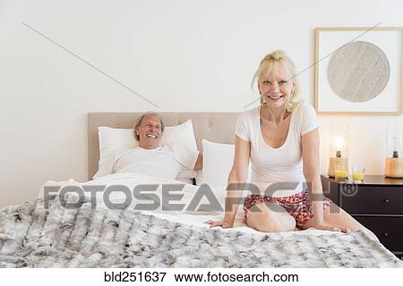 Stock Photo - Caucasian couple smiling in bed. Fotosearch