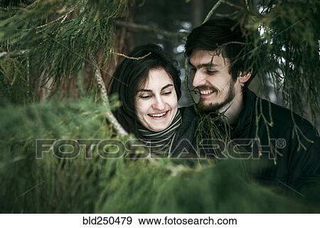 Stock Photo - Caucasian couple smiling near tree. Fotosearch