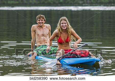 Caucasian couple straddling paddleboard View Large Photo Image Stock Image - Caucasian couple straddling paddleboard. Fotosearch