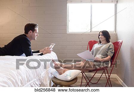 Caucasian couple using digital tablet and reading paperwork in bedroom View Large Photo Image Stock Photo - Caucasian couple using digital tablet and reading paperwork in bedroom. Fotosearch
