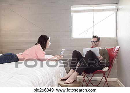 Caucasian couple using digital tablet and laptop in bedroom View Large Photo Image Stock Photo - Caucasian couple using digital tablet and laptop in bedroom. Fotosearch