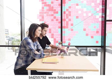 Caucasian couple using laptop at table View Large Photo Image Stock Image - Caucasian couple using laptop at table. Fotosearch