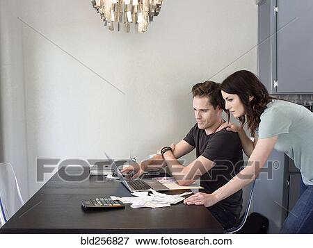 Stock Photo - Caucasian couple using laptop. Fotosearch