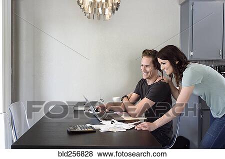 Stock Photo - Caucasian couple using laptop. Fotosearch