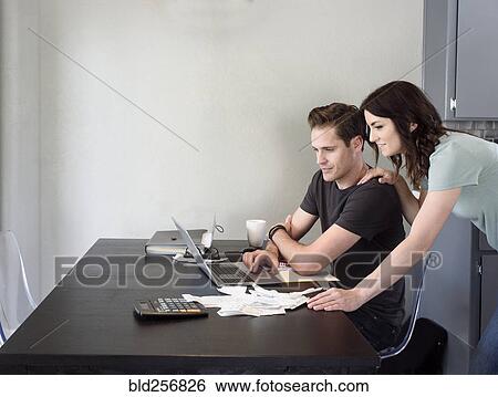Stock Photograph - Caucasian couple using laptop. Fotosearch