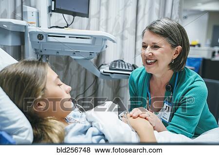 Caucasian doctor comforting patient in hospital bed View Large Photo Image Stock Photo - Caucasian doctor comforting patient in hospital bed. Fotosearch