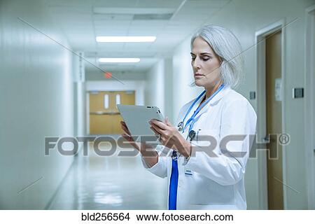 Picture - Caucasian doctor using digital tablet in hospital. Fotosearch