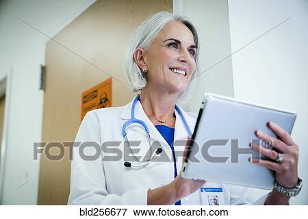 Stock Photo - Caucasian doctor using digital tablet. Fotosearch