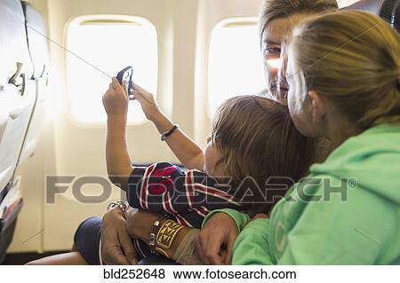 Stock Photo - Caucasian family sitting on airplane. Fotosearch