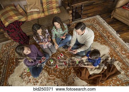 Caucasian family sitting on rug playing card game View Large Photo Image Stock Image - Caucasian family sitting on rug playing card game. Fotosearch