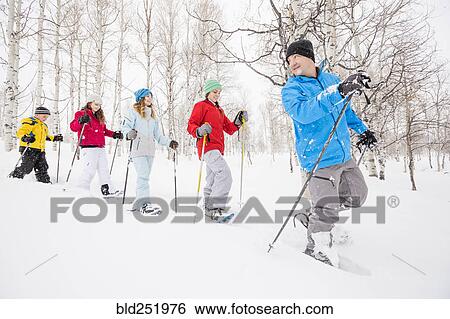 Stock Photograph - Caucasian family snowshoeing in winter. Fotosearch
