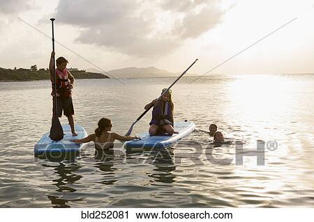 Caucasian family swimming and using paddleboards View Large Photo Image Stock Image - Caucasian family swimming and using paddleboards. Fotosearch