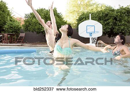 Caucasian friends playing basketball in swimming pool View Large Photo Image Stock Photo - Caucasian friends playing basketball in swimming pool. Fotosearch