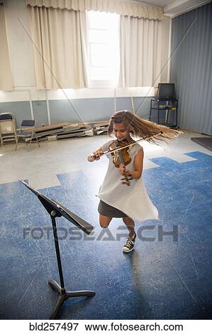Stock Photo - Caucasian girl 1acticing violin and dancing. Fotosearch