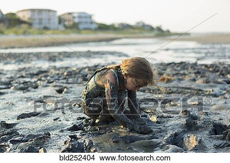 Caucasian girl covered in mud playing on beach View Large Photo Image Picture - Caucasian girl covered in mud playing on beach. Fotosearch