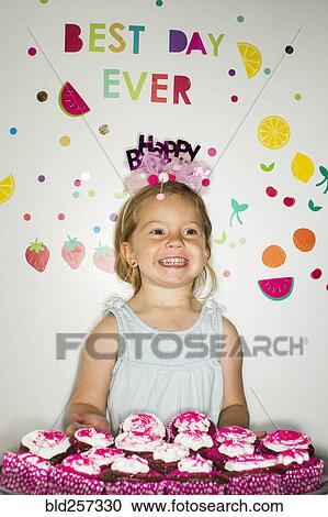 Caucasian girl holding tray of cupcakes for birthday View Large Photo Image Stock Image - Caucasian girl holding tray of cupcakes for birthday. Fotosearch