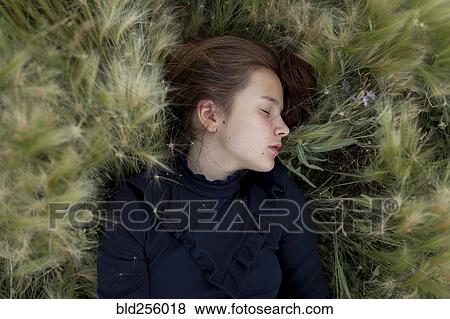 Caucasian girl laying in field View Large Photo Image Stock Photo - Caucasian girl laying in field. Fotosearch