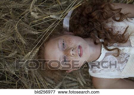 Caucasian girl laying in wheat View Large Photo Image Stock Photo - Caucasian girl laying in wheat. Fotosearch